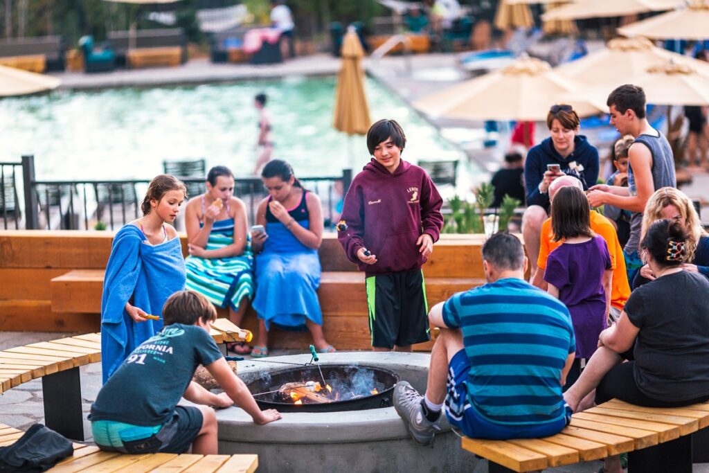 Group of kids and parents enjoying s'mores at Rush Creek Lodge Yosemite.
